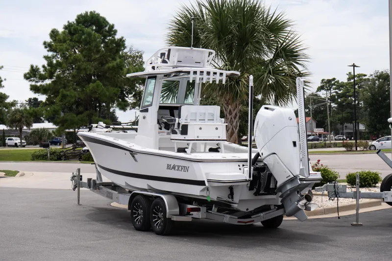 Slide: The Image of 2026 Blackfin 262 HB boat on trailer, parked outdoors near palm trees. - 6
