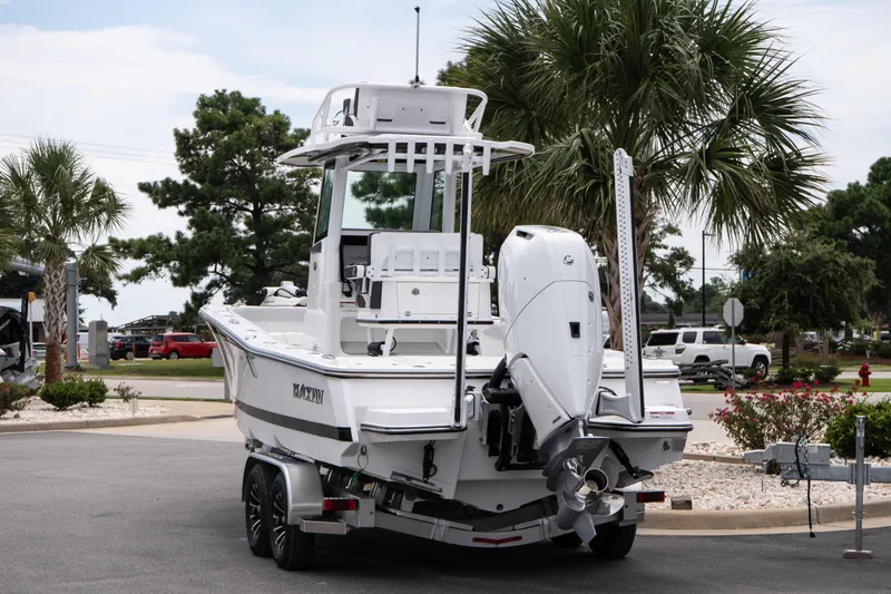 Slide: The Image of 2026 Blackfin 262 HB boat on trailer, parked near palm trees and vehicles. - 7