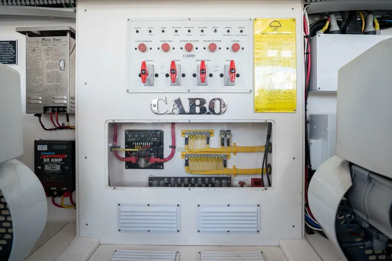 Slide: The Image of Electrical panel of a 2004 Cabo 40 Express boat, featuring switches and wiring. - 18