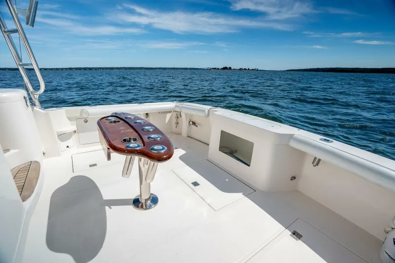 Slide: The Image of 2004 Cabo 40 Express boat deck with ocean view and fishing rod holders. - 23