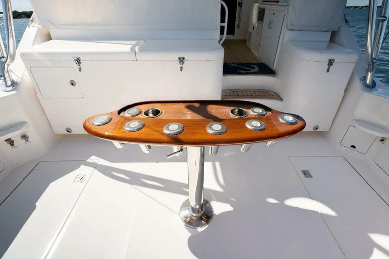 Slide: The Image of 2004 Cabo 40 Express yacht cockpit with wooden table and rod holders. - 27