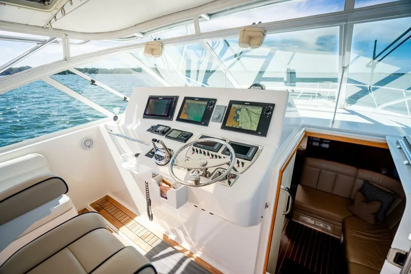 Slide: The Image of 2004 Cabo 40 Express yacht helm with navigation screens and luxurious interior. - 32