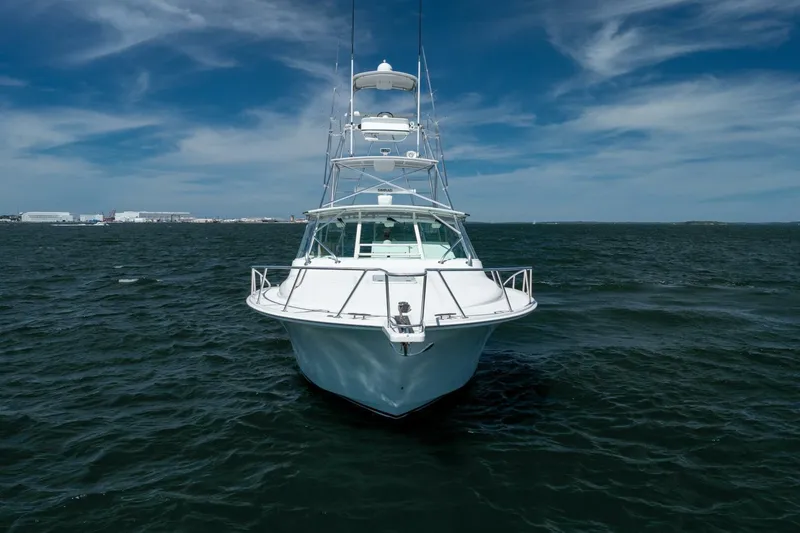 Slide: The Image of 2004 Cabo 40 Express yacht on open water under a clear blue sky. - 5