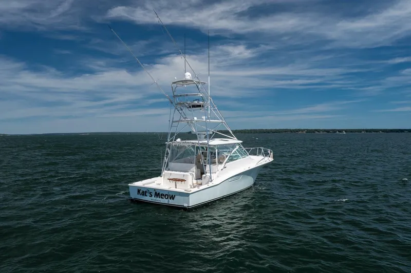 Slide: The Image of 2004 Cabo 40 Express boat on open water under a clear blue sky. - 6