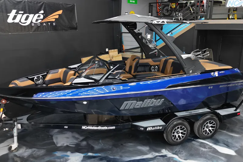 Slide: The Image of 2021 Malibu Wakesetter 20 VTX boat in showroom, blue and black design, luxury seating. - 5