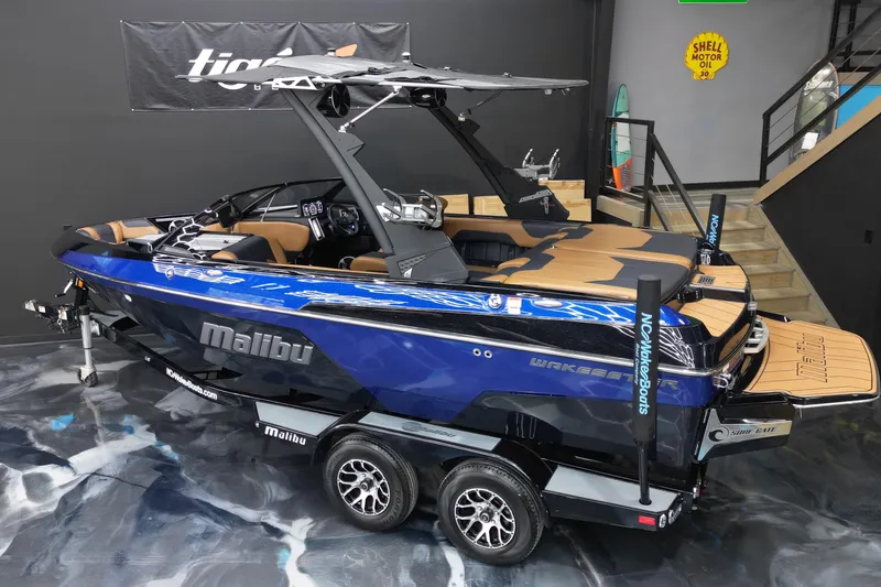 Slide: The Image of 2021 Malibu Wakesetter 20 VTX boat in showroom, blue exterior, on trailer. - 7