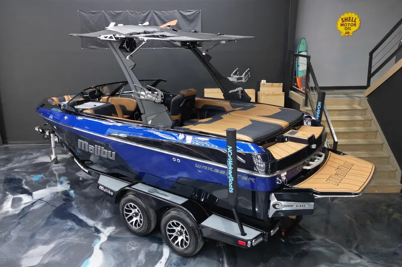 Slide: The Image of 2021 Malibu Wakesetter 20 VTX boat in showroom, blue exterior, luxury interior, on trailer. - 8