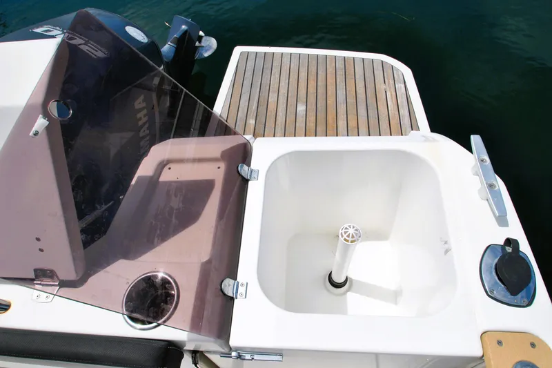 Slide: The Image of 2019 Jeanneau NC 795 Sport boat deck with Yamaha engine and storage compartment. - 26