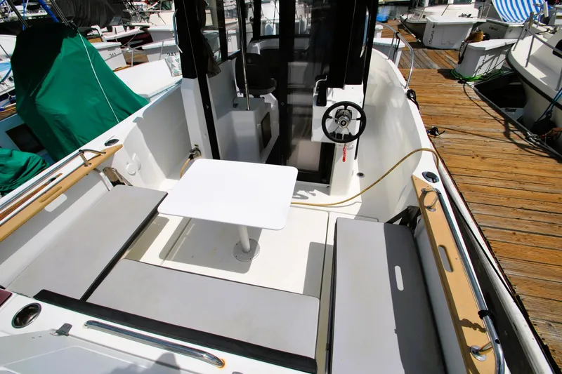 Slide: The Image of 2019 Jeanneau NC 795 Sport boat interior with seating and table at dock. - 29