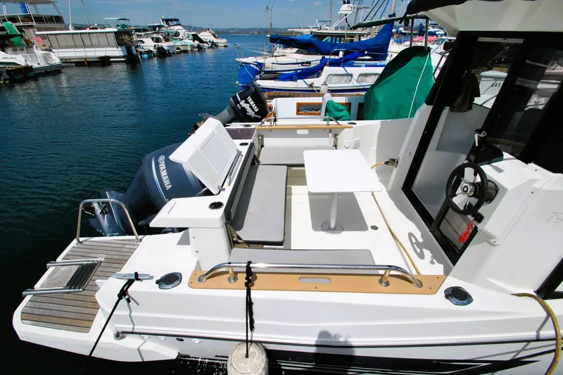 Slide: The Image of 2019 Jeanneau NC 795 Sport boat docked, featuring spacious deck and Yamaha outboard motor. - 30