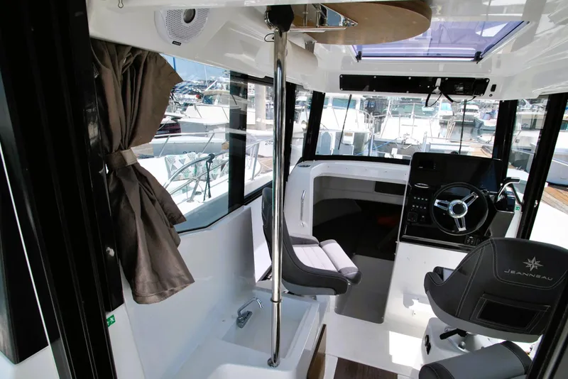 Slide: The Image of Interior of 2019 Jeanneau NC 795 Sport boat with steering wheel and seating. - 8