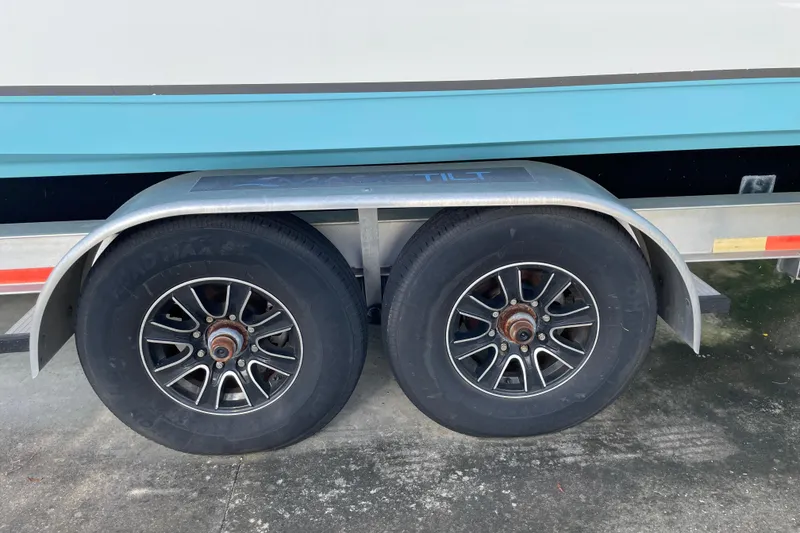 Slide: The Image of Trailer wheels of a 2020 NauticStar 28 XS boat on concrete surface. - 27
