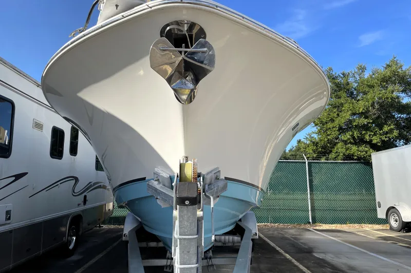 Slide: The Image of 2020 NauticStar 28 XS boat on trailer, parked outdoors under clear blue sky. - 5