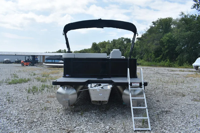 Slide: The Image of 2026 Godfrey SWEETWATER 2086SB pontoon boat with ladder, parked on gravel lot. - 2