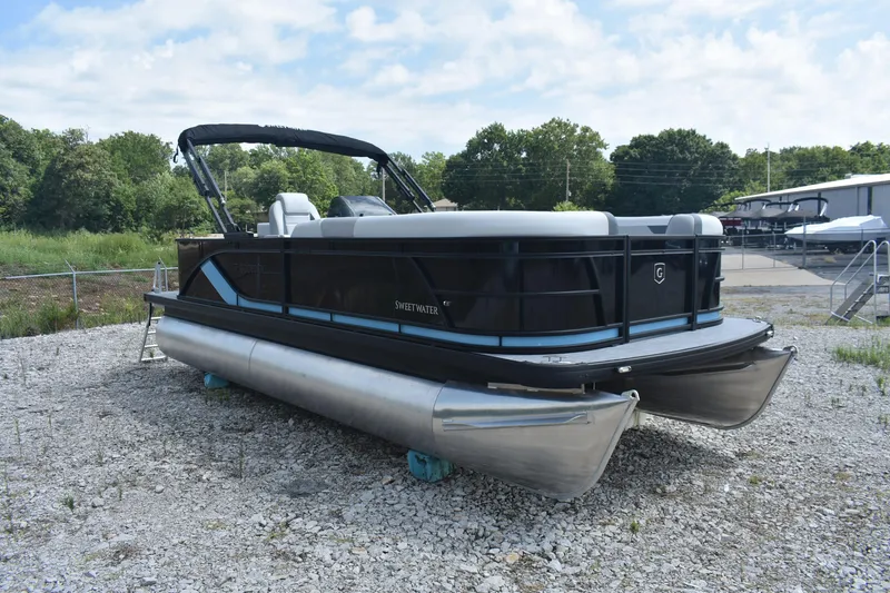 Slide: The Image of 2026 Godfrey SWEETWATER 2086SB pontoon boat on gravel lot, surrounded by trees. - 5