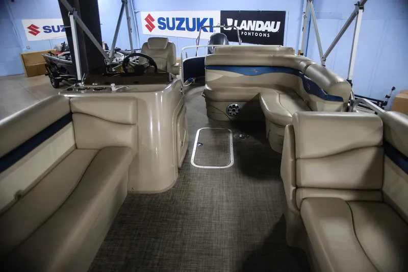 Slide: The Image of 2015 Bennington 24 SSLX pontoon boat interior with beige seating and steering console. - 14