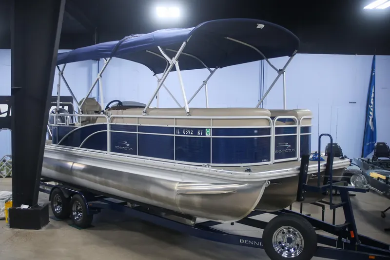 Slide: The Image of 2015 Bennington 24 SSLX pontoon boat on trailer in indoor showroom. - 2