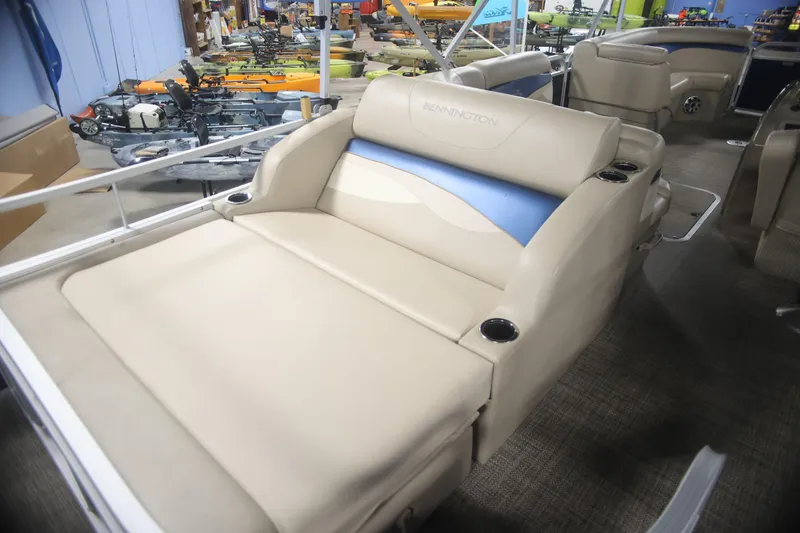 Slide: The Image of 2015 Bennington 24 SSLX pontoon boat with beige seating and cup holders in showroom. - 7