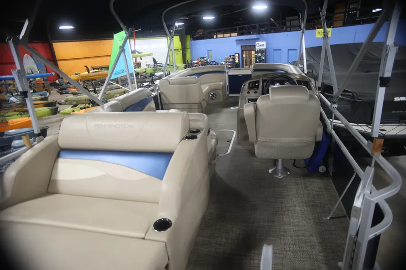Slide: The Image of 2015 Bennington 24 SSLX pontoon boat interior with beige seating and steering console. - 8