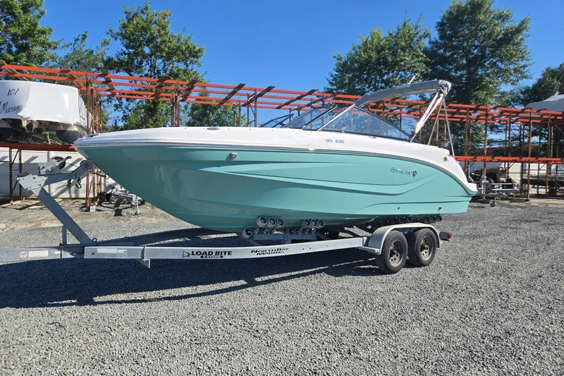 The Image of 2026 Hurricane SunDeck 235 OB boat on trailer, parked outdoors. - 0