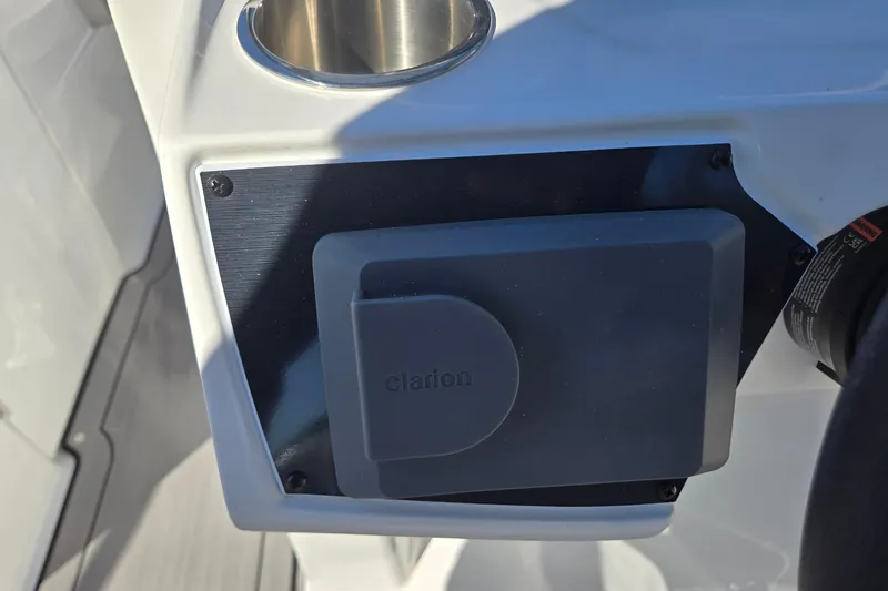 Slide: The Image of 2026 Hurricane SunDeck 235 OB boat console with Clarion audio system and cup holder. - 19