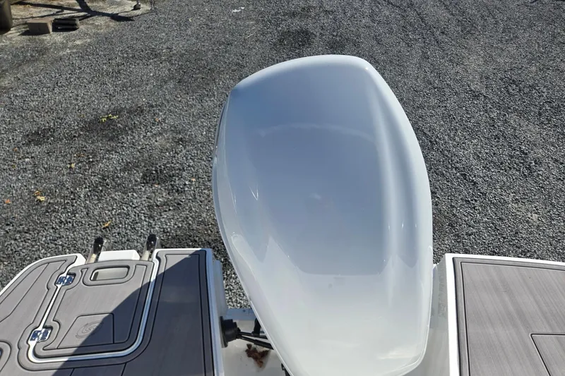 Slide: The Image of 2026 Hurricane SunDeck 235 OB boat engine and deck on gravel surface. - 29