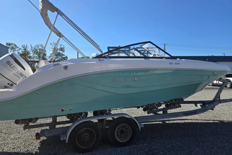 Slide: The Image of 2026 Hurricane SunDeck 235 OB boat on trailer, featuring sleek design and Suzuki outboard motor. - 6