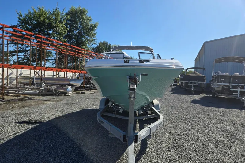 Slide: The Image of 2026 Hurricane SunDeck 235 OB boat on trailer in outdoor storage area. - 9
