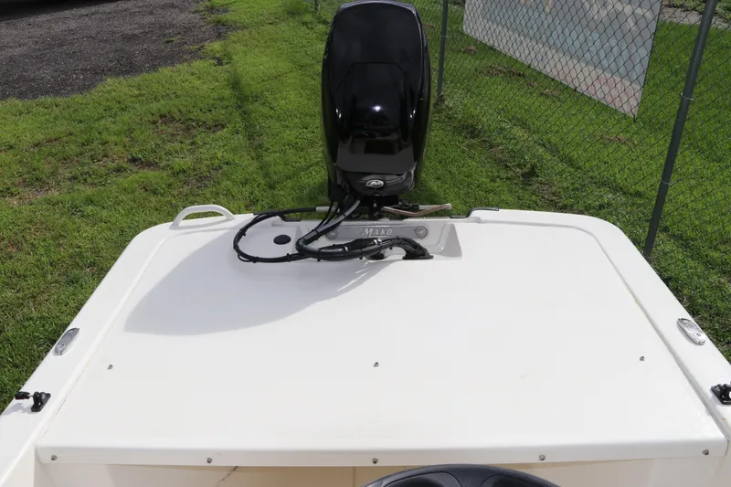 Slide: The Image of 2023 Mako Pro Skiff 13 CC boat with outboard motor, parked on grass. - 11