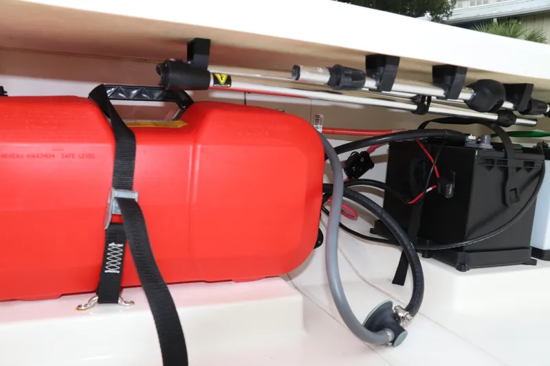 Slide: The Image of 2023 Mako Pro Skiff 13 CC storage with red fuel tank and battery setup. - 15