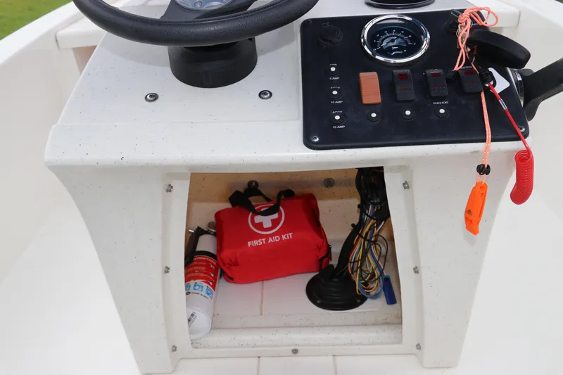 Slide: The Image of 2023 Mako Pro Skiff 13 CC console with controls, first aid kit, and safety equipment. - 22