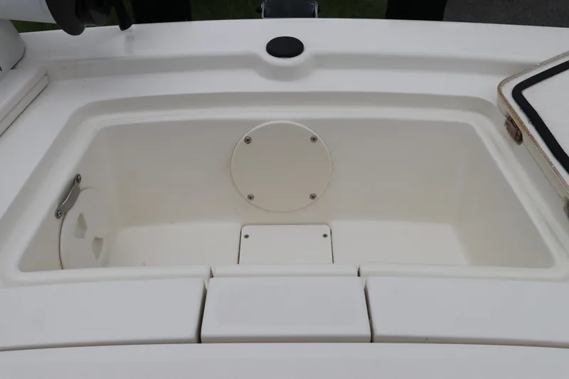 Slide: The Image of 2023 Mako Pro Skiff 13 CC storage compartment, white interior, open hatch. - 23