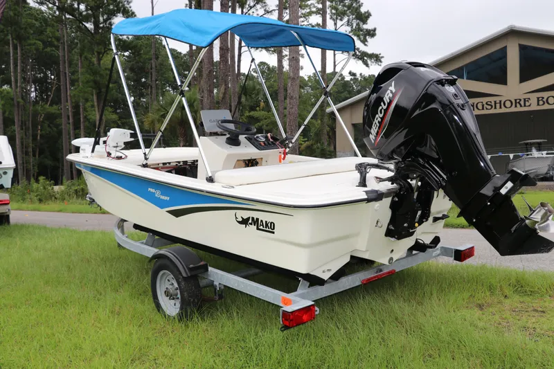 Slide: The Image of 2023 Mako Pro Skiff 13 CC boat with Mercury engine and blue canopy on trailer. - 5