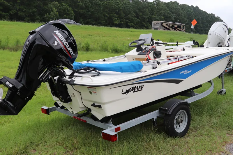 Slide: The Image of 2023 Mako Pro Skiff 13 CC boat on trailer, featuring Mercury outboard motor. - 6