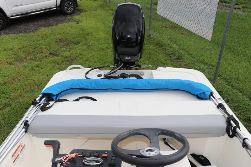 Slide: The Image of 2023 Mako Pro Skiff 13 CC boat interior with steering wheel and motor. - 9
