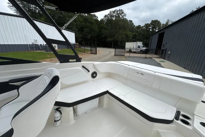 Slide: The Image of 2023 Searay SPX 210 IO boat interior with white seating and black accents. - 21