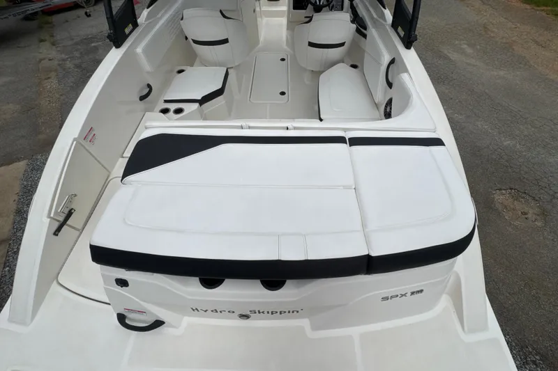Slide: The Image of 2023 Searay SPX 210 IO boat interior with white seating and black accents. - 24