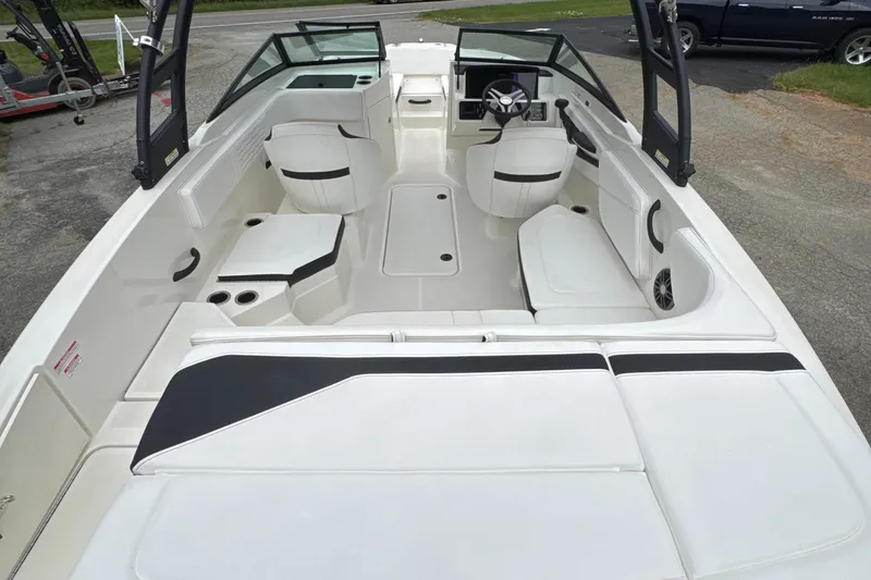 Slide: The Image of 2023 Searay SPX 210 IO boat interior with white seating and modern dashboard. - 25