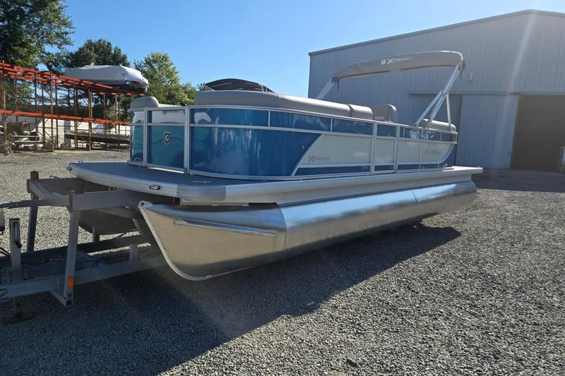 The Image of 2026 Godfrey Xperience 2286 SBX pontoon boat on trailer, parked outdoors. - 0