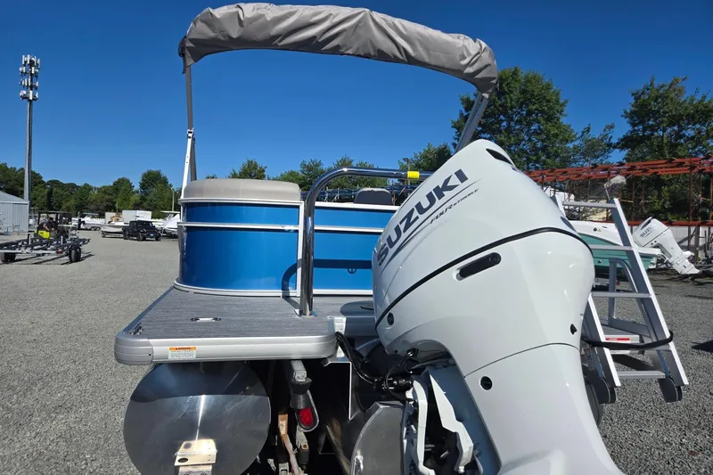 Slide: The Image of 2026 Godfrey Xperience 2286 SBX pontoon boat with Suzuki outboard motor in a sunny outdoor setting. - 3