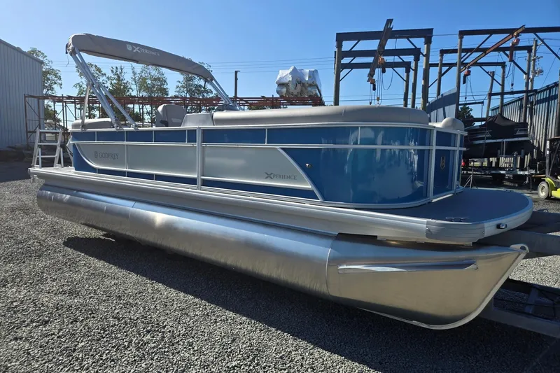 Slide: The Image of 2026 Godfrey Xperience 2286 SBX pontoon boat in a storage yard, side view. - 7