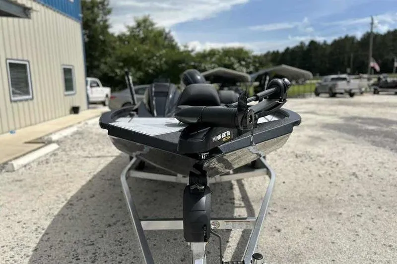 Slide: The Image of 2026 Xpress H18 Bay boat on trailer, featuring Minn Kota motor, parked outdoors. - 5