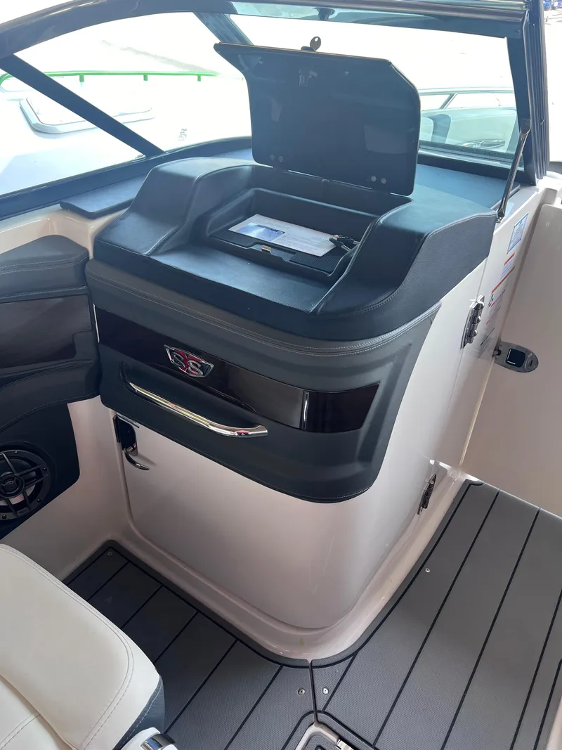 Slide: The Image of 2022 Chaparral 267 SSX boat interior dashboard with storage compartment. - 18