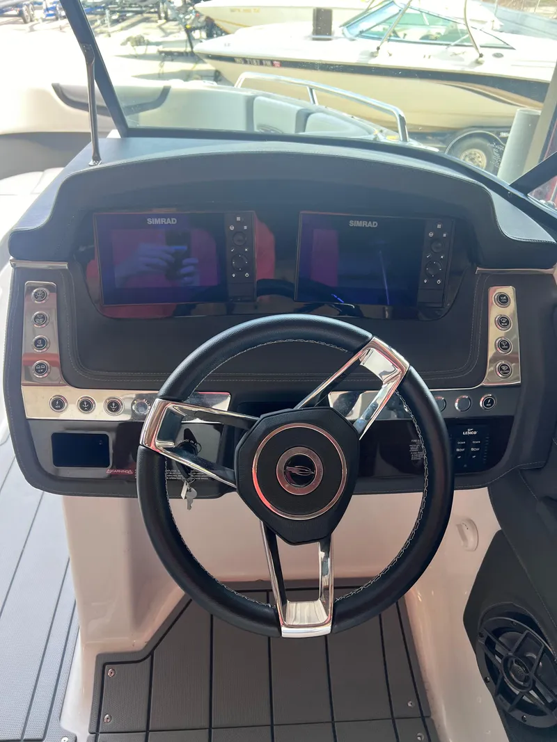 Slide: The Image of 2022 Chaparral 267 SSX boat dashboard with steering wheel and dual displays. - 21