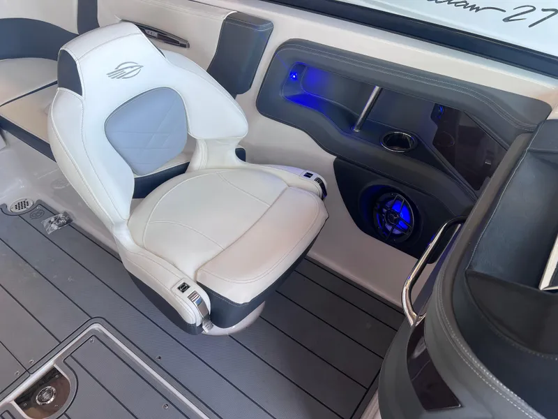 Slide: The Image of 2022 Chaparral 267 SSX boat interior with white and gray seating and blue LED lighting. - 27