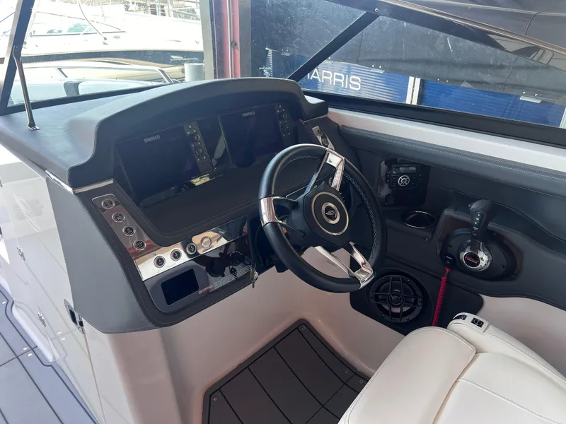 Slide: The Image of 2022 Chaparral 267 SSX boat cockpit with steering wheel and control panel. - 29