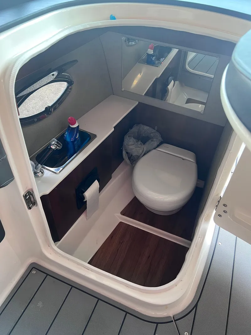 Slide: The Image of 2022 Chaparral 267 SSX boat interior bathroom with sink and toilet. - 30