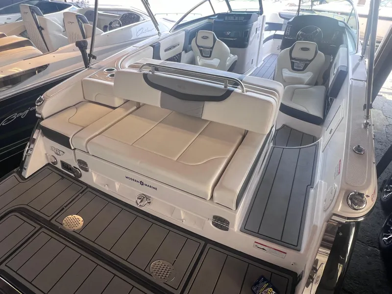 Slide: The Image of 2022 Chaparral 267 SSX boat with white and gray seating and deck. - 44