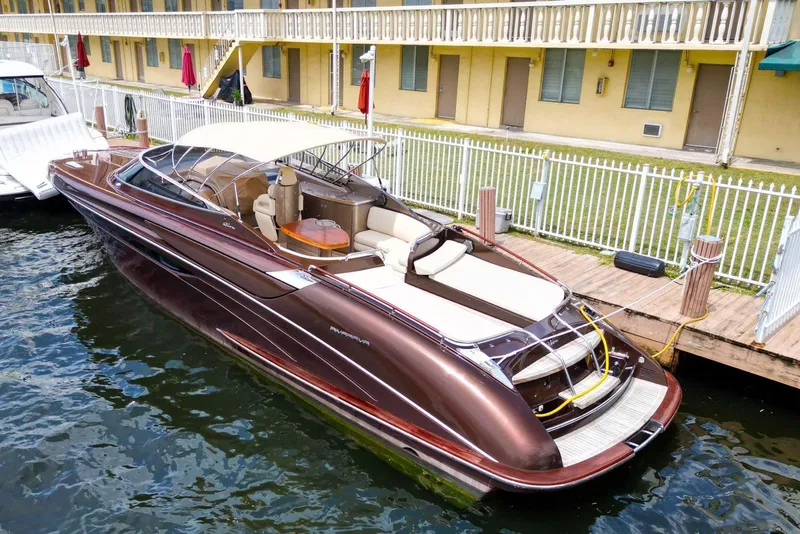 The Image of Luxurious 2005 Riva RivaRama 44 yacht docked by a waterfront building. - 0