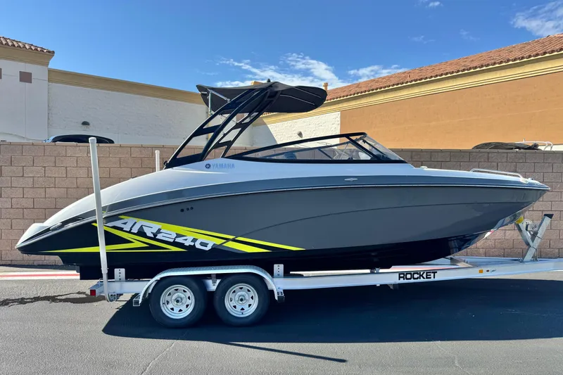 The Image of 2020 Yamaha AR240 boat on trailer, sleek design, parked outdoors. - 0